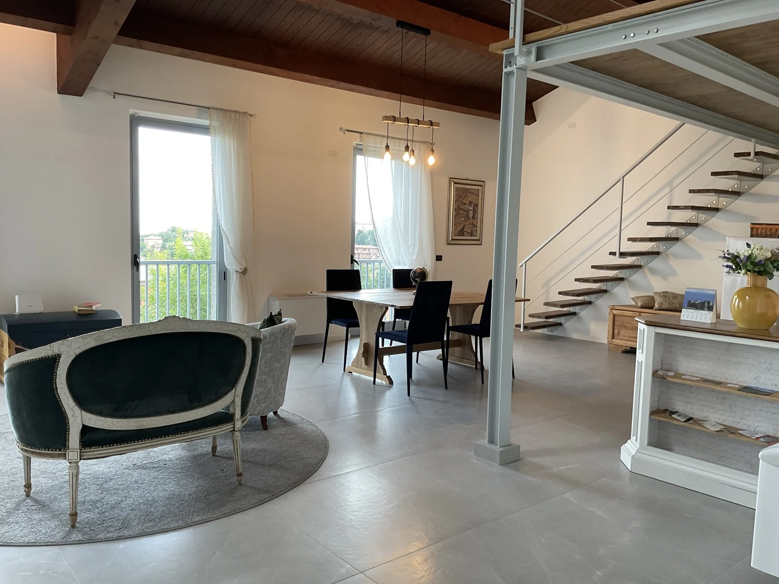 Deltasol shared living area with exposed beams, a dining table and natural window light