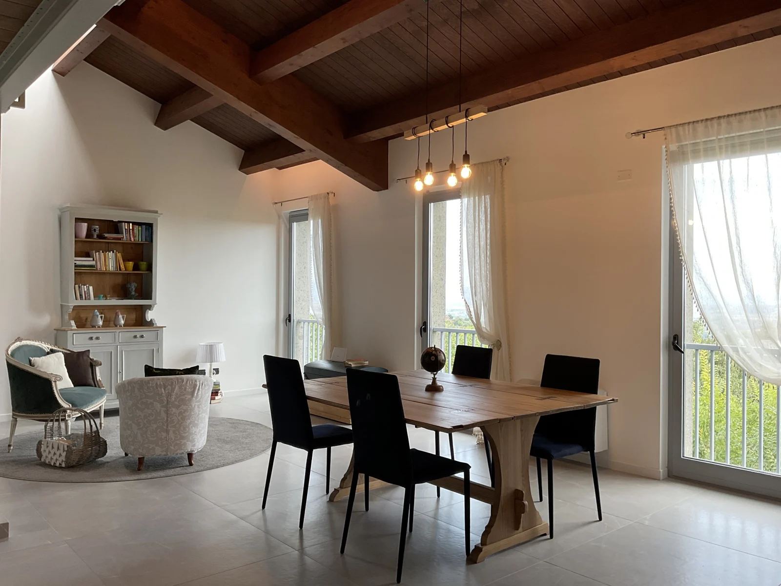 Shared living area with seating, a dining table and bright windows